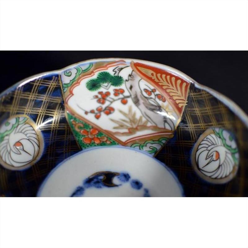Close-up of an antique hand painted Japanese Imari porcelain bowl with bird and floral patterns.