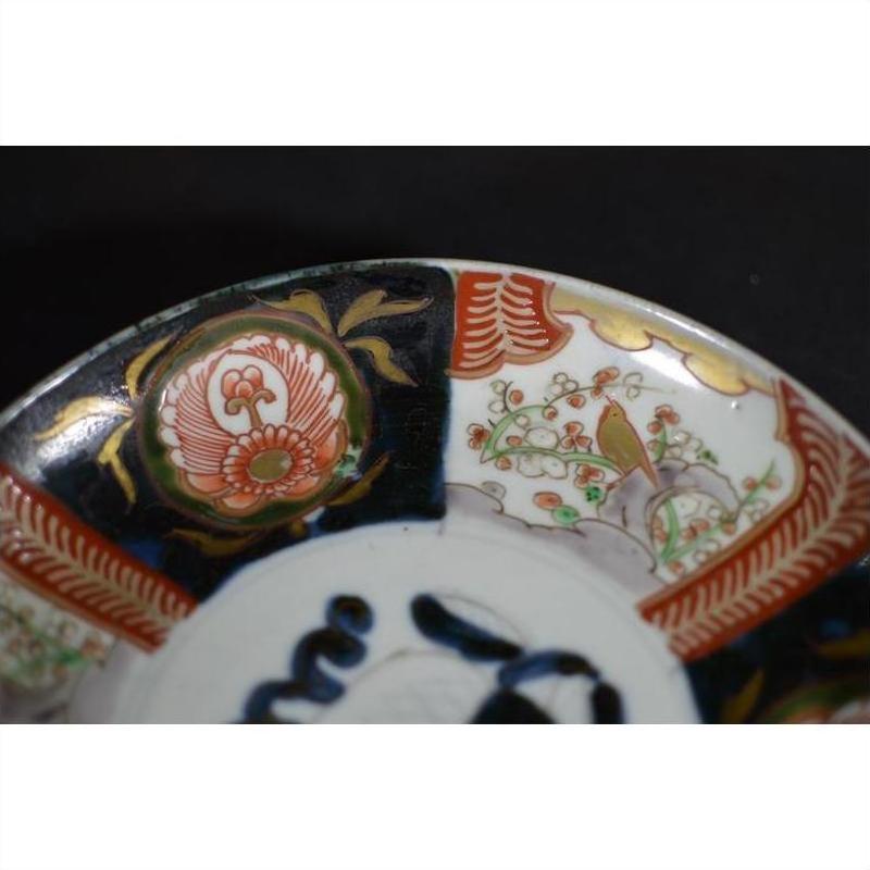 Close-up of a multicolored porcelain Japanese Imari bowl with hand-painted floral and bird patterns.