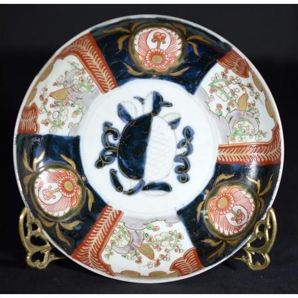 Multicolored porcelain Imari bowl with hand painted turtle and floral motifs, close-up of antique Japanese design.