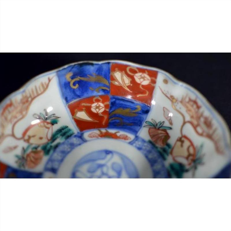 Close-up of a red, blue, and gold floral Japanese Imari porcelain bowl, antique, hand painted.