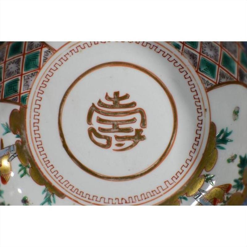Close-up of antique hand painted Japanese Imari porcelain bowl base with red character and colorful patterns.