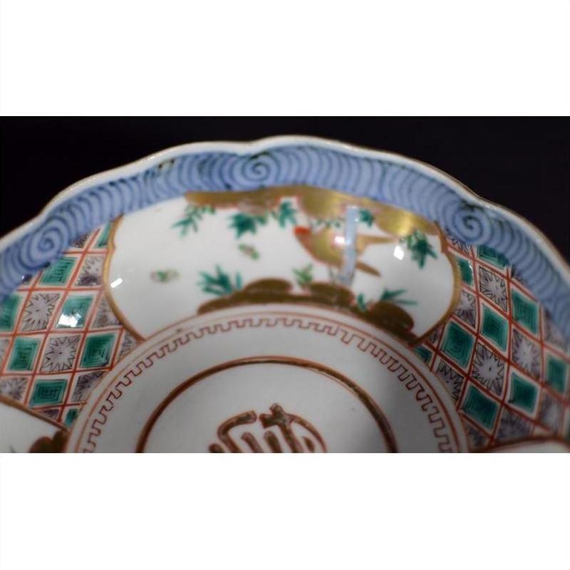 Close-up of colorful hand-painted Japanese Imari porcelain bowl with bird and bamboo patterns.