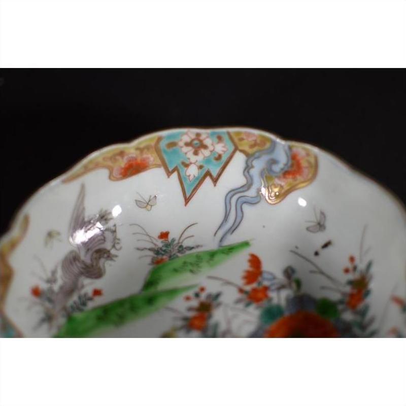 Close-up of an antique hand-painted Japanese Imari porcelain bowl with floral designs and a vibrant ornate rim.