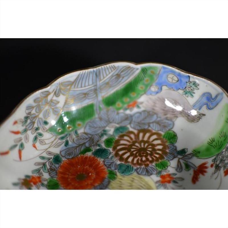 Close-up of a black porcelain Japanese Imari bowl with hand painted vibrant floral and bird patterns.