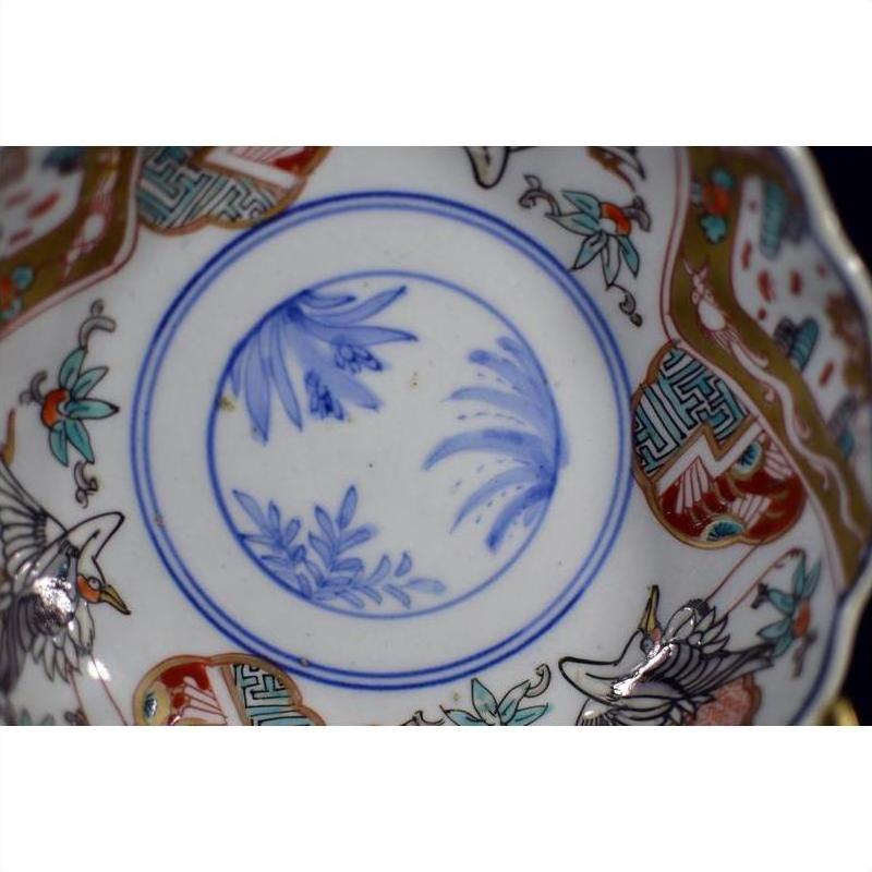 Close-up of blue and white hand painted Japanese Imari porcelain bowl with floral, bird, and geometric designs.