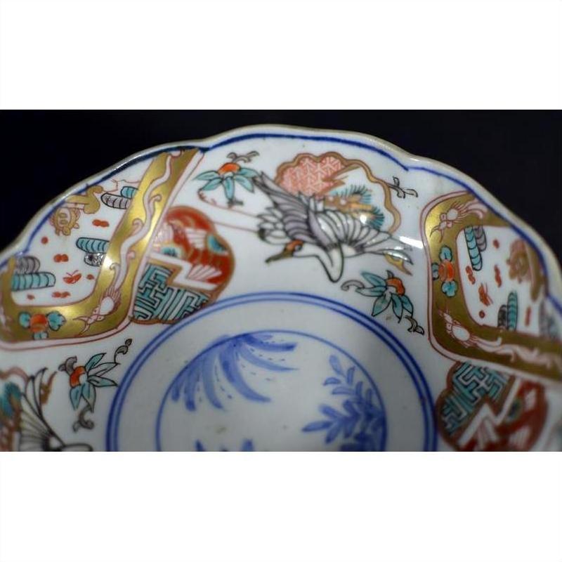 Close-up of blue, gold, red, and green hand painted Japanese Imari porcelain bowl with floral and bird designs.