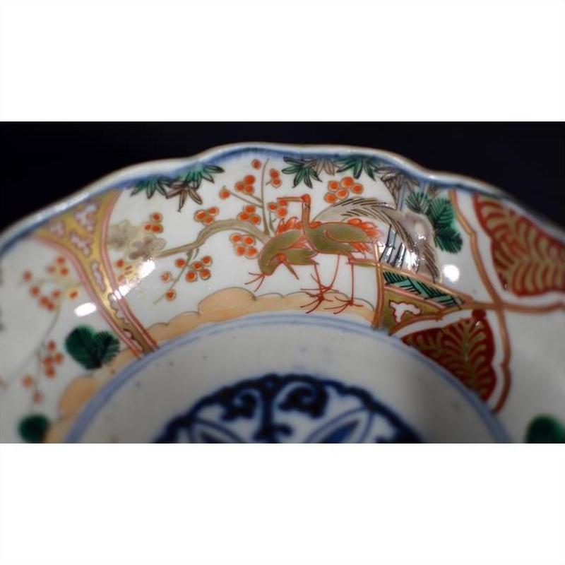 Close-up of red, green, and gold hand painted porcelain Japanese Imari bowl with antique patterns.