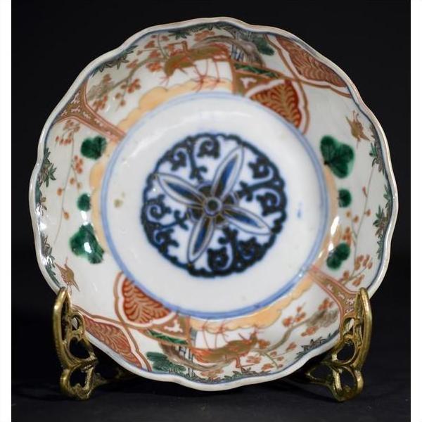 Close-up of blue, green, and orange hand painted Japanese Imari porcelain bowl on brass stand.