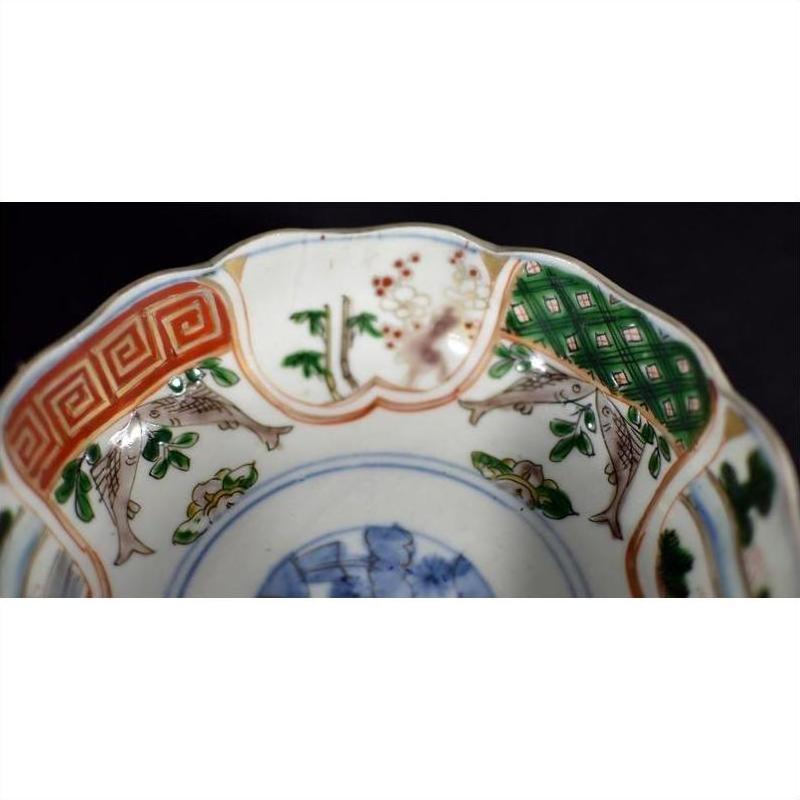 Close-up of colorful hand painted Japanese Imari porcelain bowl with scalloped rim and intricate patterns.