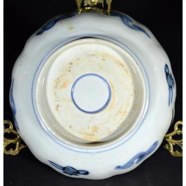 Close-up of antique hand painted Japanese Imari porcelain bowl on gold-colored metal stand.
