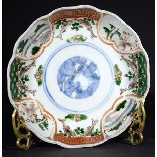 Colorful porcelain Japanese Imari bowl with hand-painted florals and bold blue circular motif, close-up.