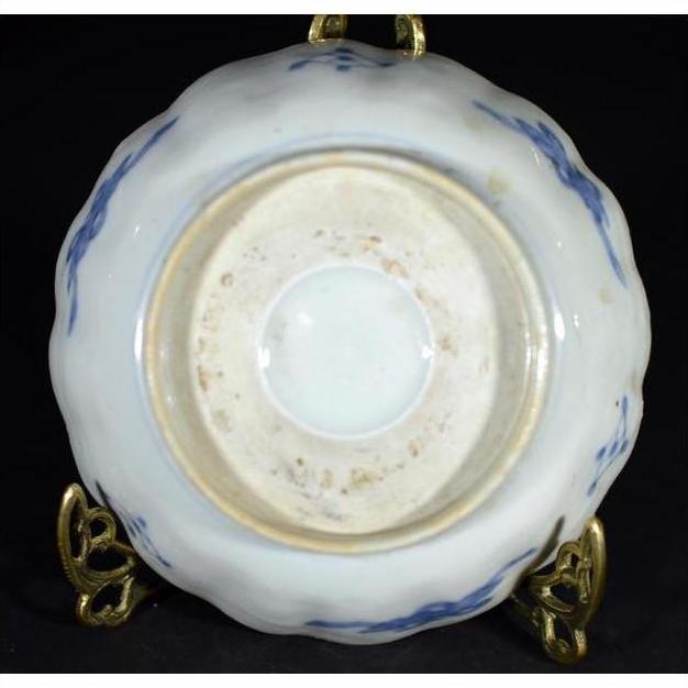 Close-up of the underside of an antique hand painted Japanese Imari porcelain bowl on a brass stand.