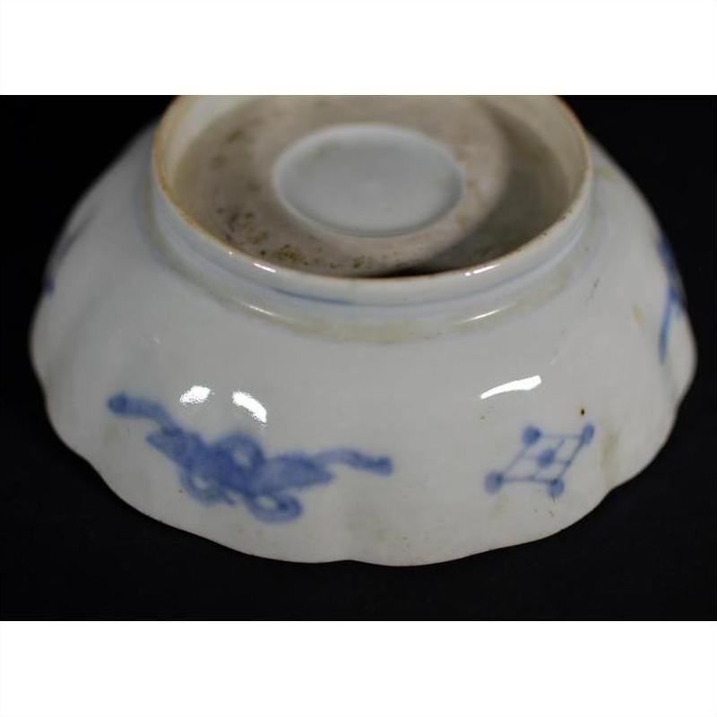Blue and white porcelain Japanese Imari bowl, hand painted, upside down against a black background.