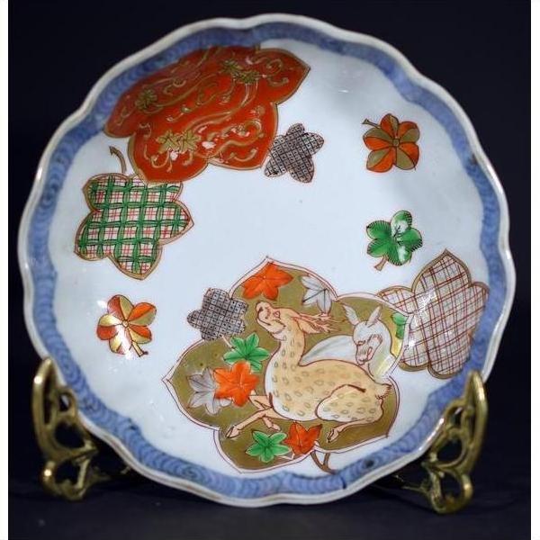 Blue and white hand painted Japanese Imari porcelain bowl on ornate brass stand, close-up.