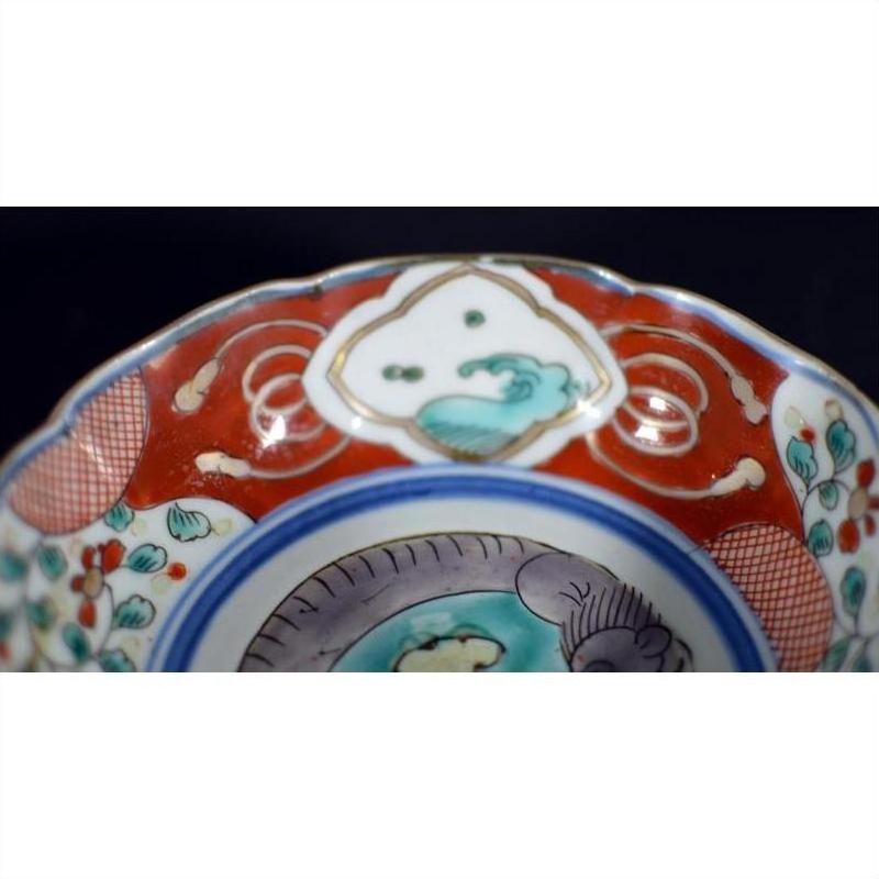 Close-up of a colorful hand painted Japanese Imari porcelain bowl with floral and geometric patterns.