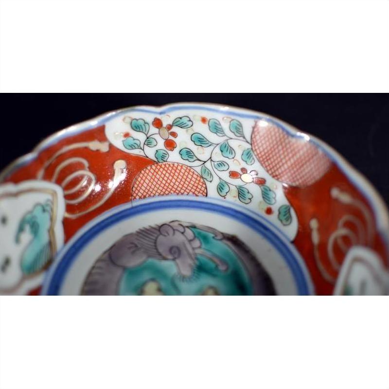 Close-up of a multicolored porcelain Japanese Imari bowl with red, white, green, and blue hand-painted floral designs.