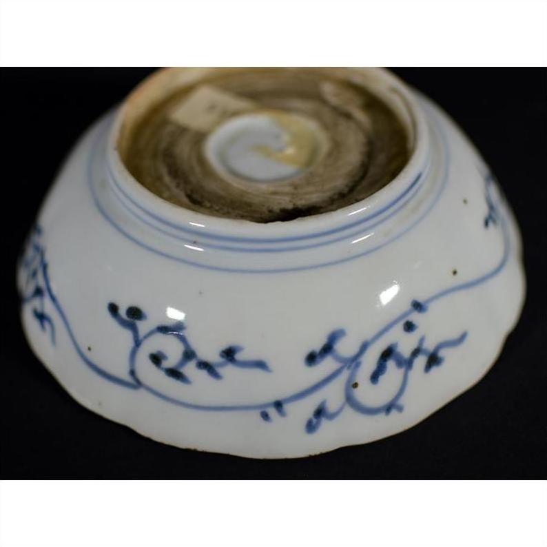 Blue and white porcelain bowl upside-down, hand painted with florals, showing worn circular base mark.