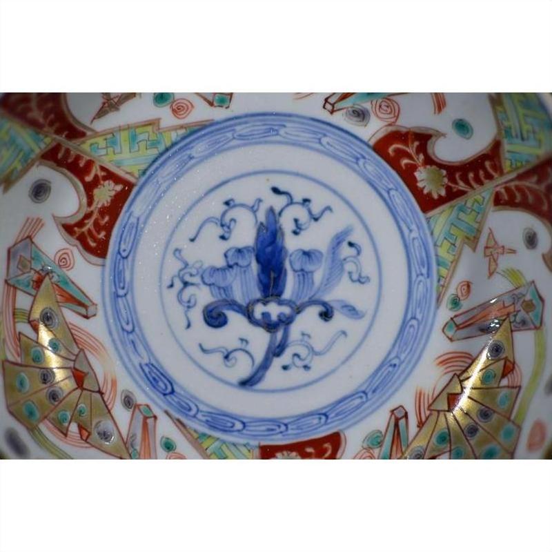 Close-up of a blue, red, gold, and green hand painted Japanese Imari porcelain bowl with floral and geometric patterns.