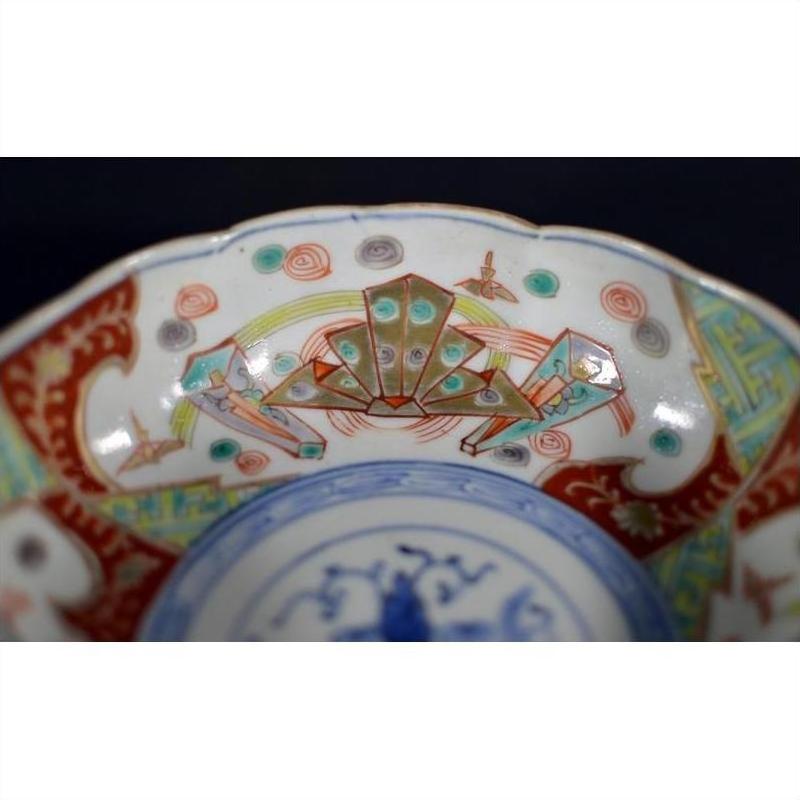 Colorful porcelain Japanese Imari bowl with hand-painted crab design on inner rim, antique style, close-up view.