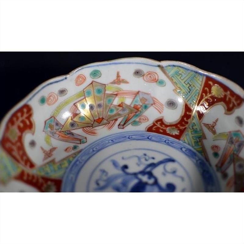 Close-up of colorful hand painted Japanese Imari porcelain bowl with geometric and intricate rim designs.