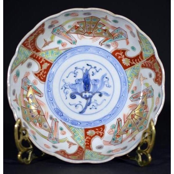 Close-up of red, blue, and gold hand painted Japanese Imari porcelain bowl with blue floral center motif.