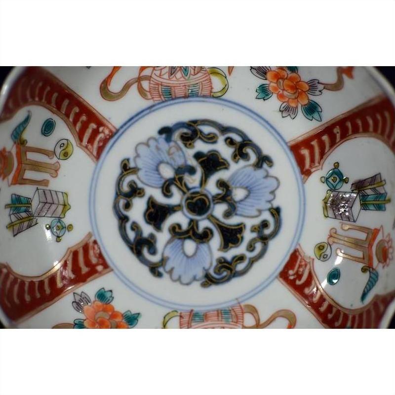 Close-up of blue, red, green, and gold hand painted Japanese Imari porcelain bowl with antique patterns.