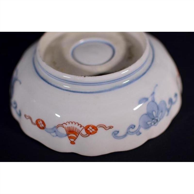 Close-up of the base of a blue and red porcelain Japanese Imari bowl with hand-painted floral patterns.