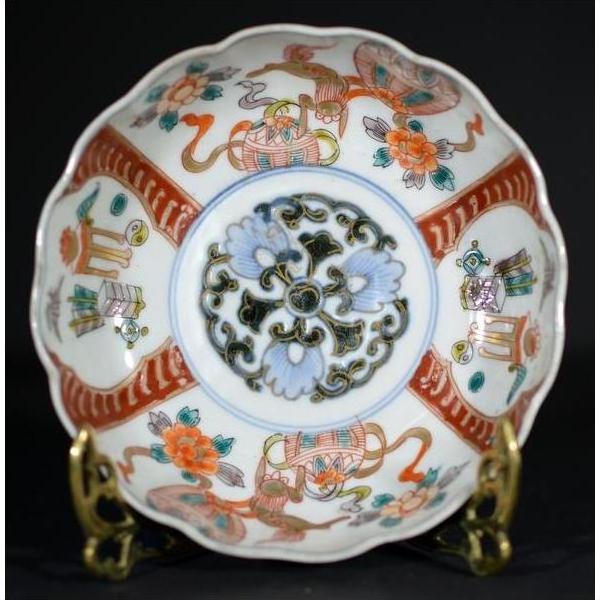 Close-up of antique Japanese Imari porcelain bowl with red, blue, green, and orange floral and geometric patterns.