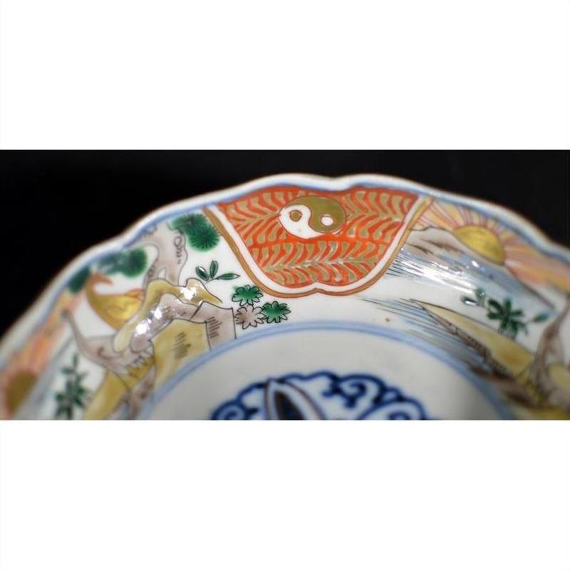 Close-up of an antique hand painted Japanese Imari porcelain bowl with vibrant traditional patterns on the rim.