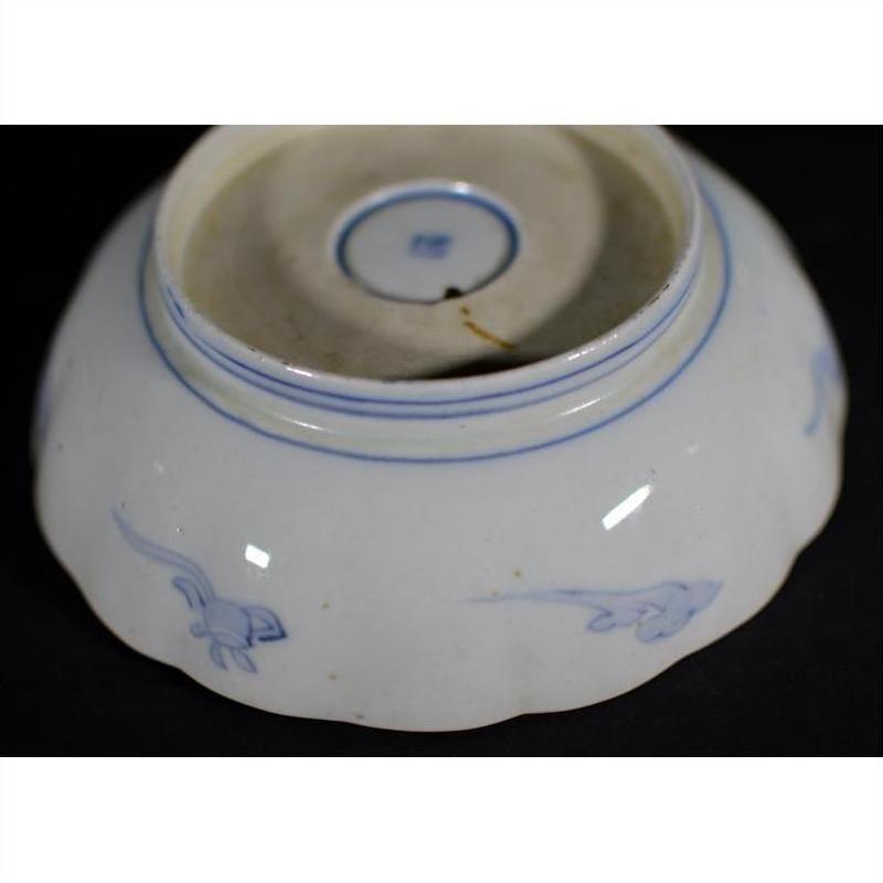 Multicolor porcelain bowl upside down, hand painted with Imari design, set against a black background.