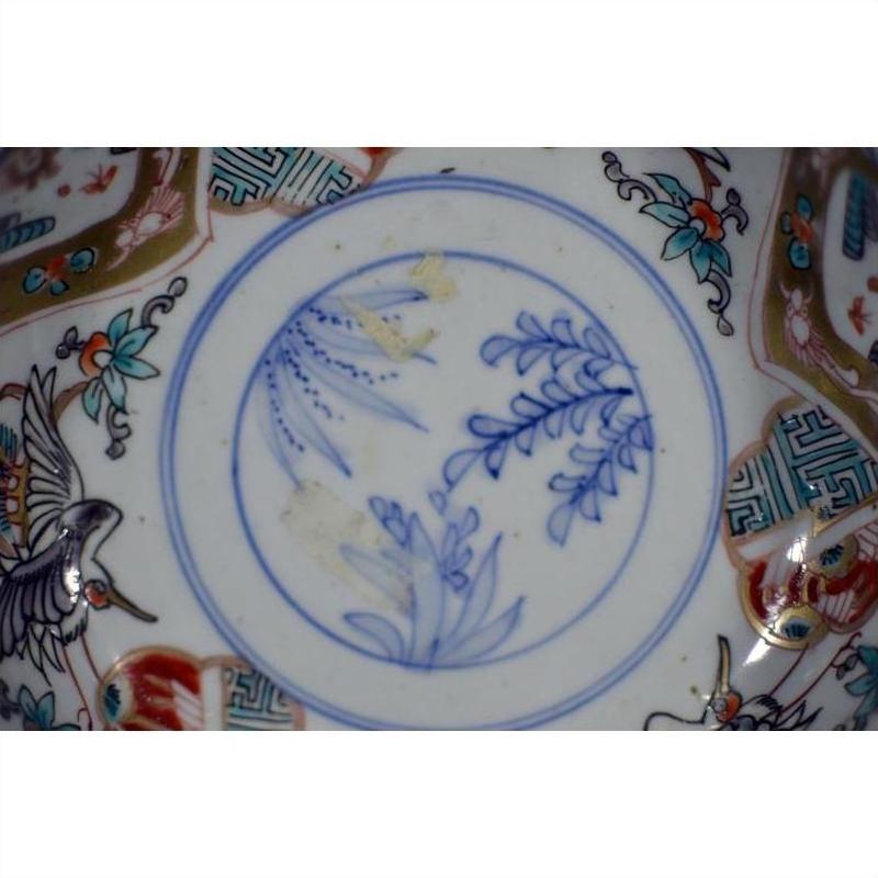 Close-up of blue and multicolor hand painted Japanese Imari porcelain bowl with floral and crane designs.