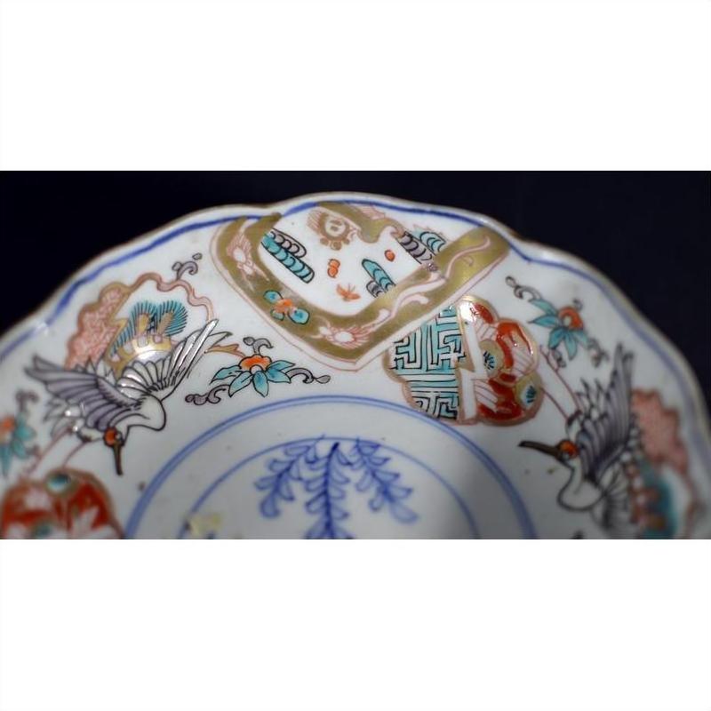 Close-up of blue, red, green, and gold Imari porcelain bowl with floral and bird motifs, antique hand-painted design.