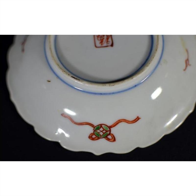 Close-up of bottom of antique Japanese Imari porcelain plate, red and green painted designs, central red stamp.