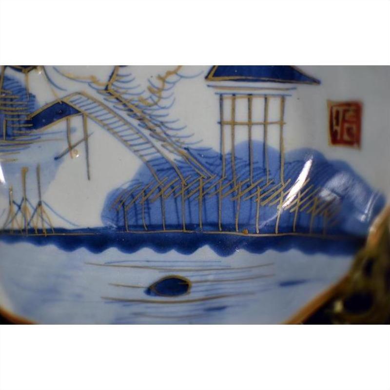 Close-up of blue and white hand painted porcelain Japanese Imari plate featuring a landscape design.