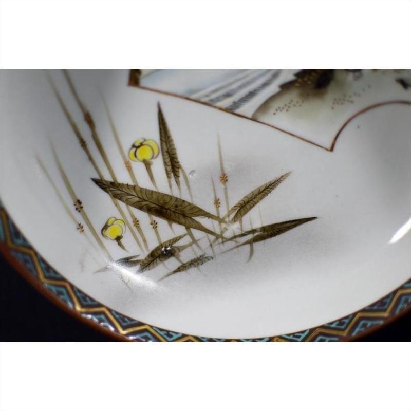 Close-up of antique hand painted Japanese Kutani porcelain bowl with yellow flowers and vintage patterned edge.