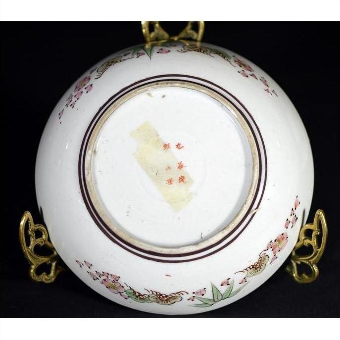 Close-up of the base of an antique hand painted Japanese Kutani porcelain bowl on a metal stand.