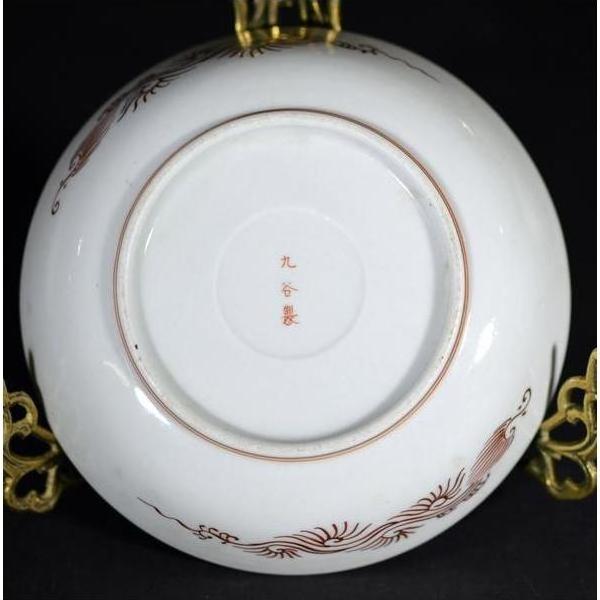 Close-up of the underside of an antique hand painted Japanese Kutani porcelain plate on a gold stand.