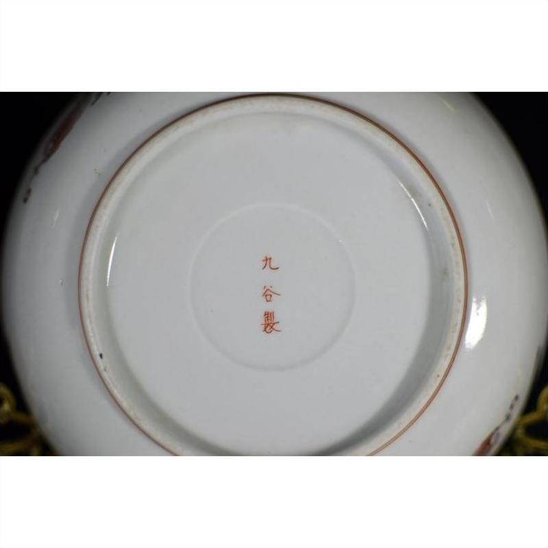 Close-up of the base of an antique hand painted Japanese Kutani porcelain plate with red Japanese characters in center.