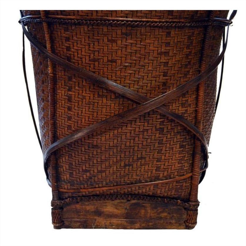 Natural rattan handwoven farmer's basket with crisscrossed wooden supports and sturdy wood base, front view.