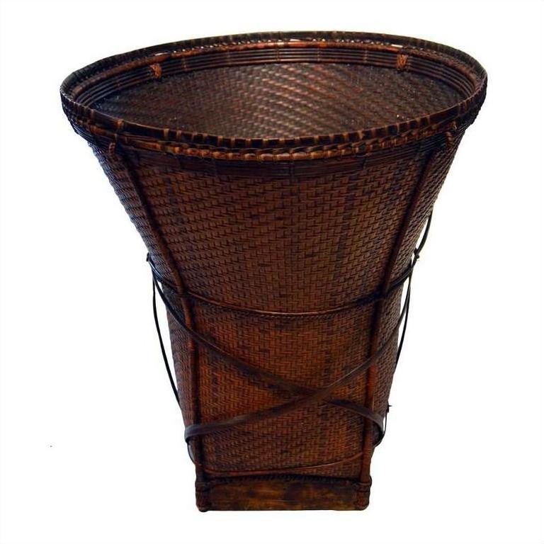 Natural rattan cone-shaped farmer's basket with wide opening and narrow wooden base, close-up.