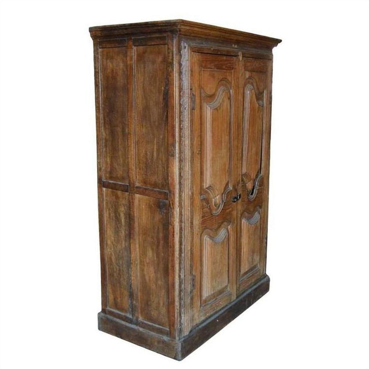Warm wood antique Indian cabinet with intricately carved doors, angled view.