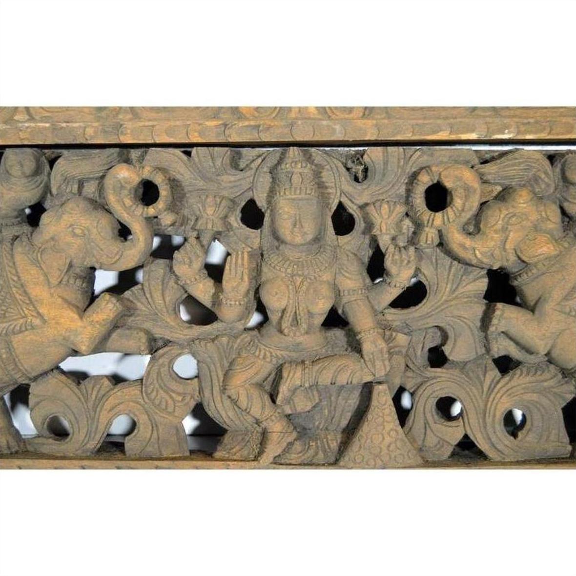 Brown sheesham wood hand-carved temple plaque with deity, elephants, and floral motifs, early 20th century.