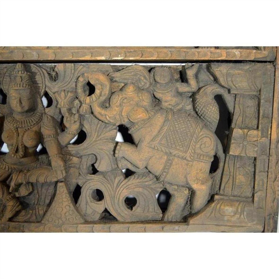 Brown Sheesham wood temple plaque with hand-carved elephant, deity, and ornate floral design, early 20th century.