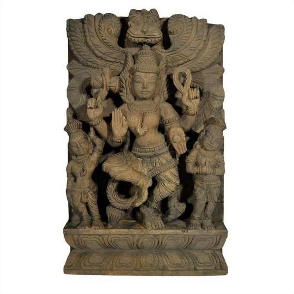 Brown sheesham wood temple decoration with multi-armed deity, attendants, and ornate carvings on pedestal, close-up.