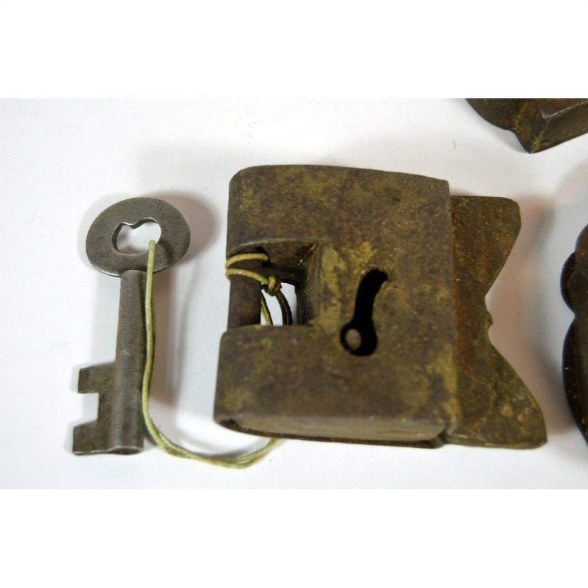 Close-up of rusted metal antique Indian locks with original key on a white surface.