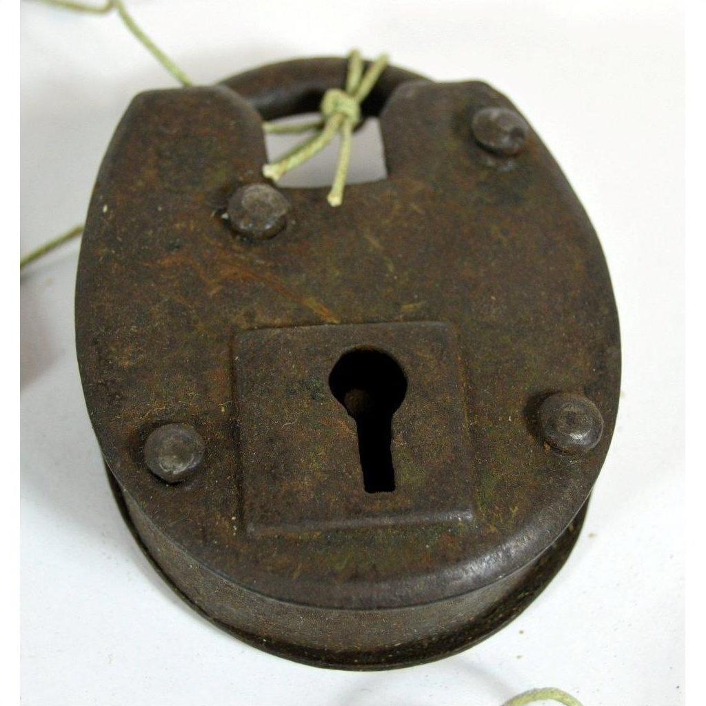 Close-up of rustic metal antique Indian lock with keyhole and string looped through the top shackle.