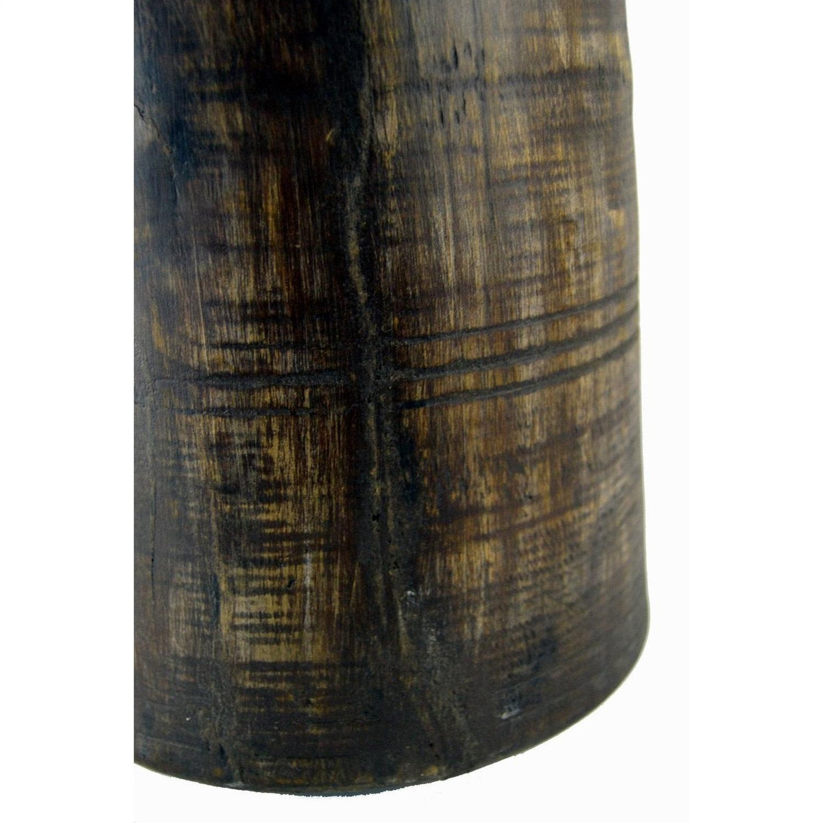 Close-up of a brown antique Indian milk storage container, cylindrical with carved horizontal and vertical lines.