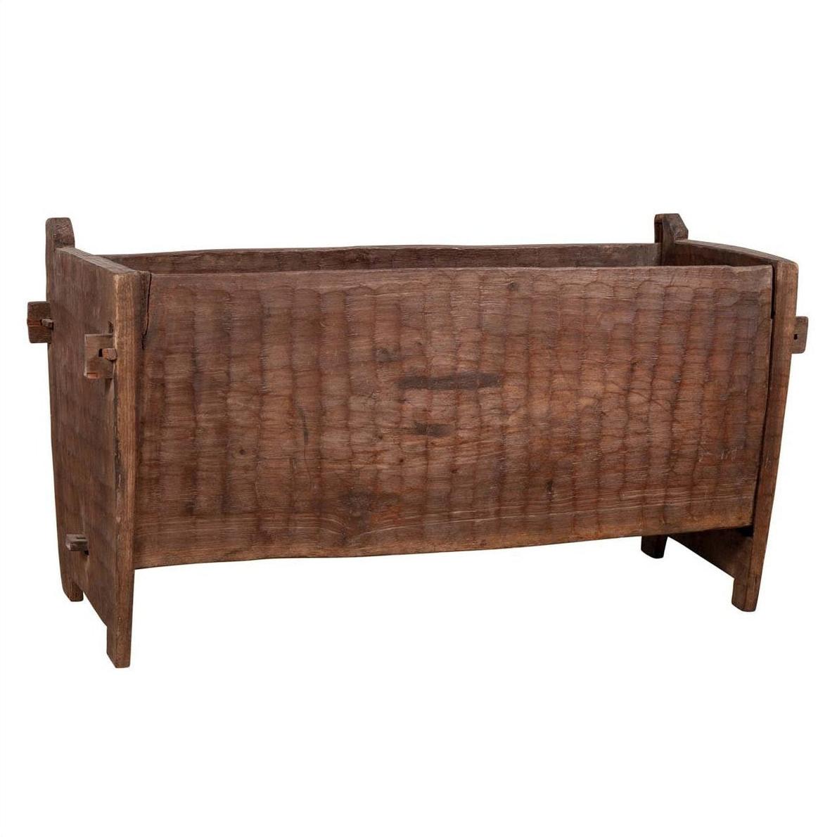 Brown wooden planter with weathered, chiseled texture and four legs, rectangular shape, rustic style.