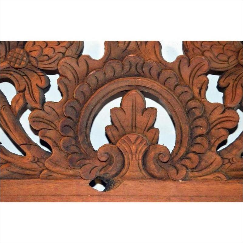 Brown wood Indonesian carving with central leaf design and ornate floral accents, suitable for wall or home décor.