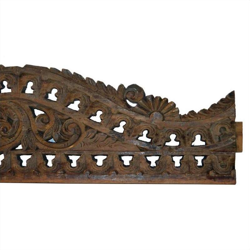 Brown wood Indonesian wall carving with ornate floral and leaf patterns, intricate cutouts along the bottom edge.